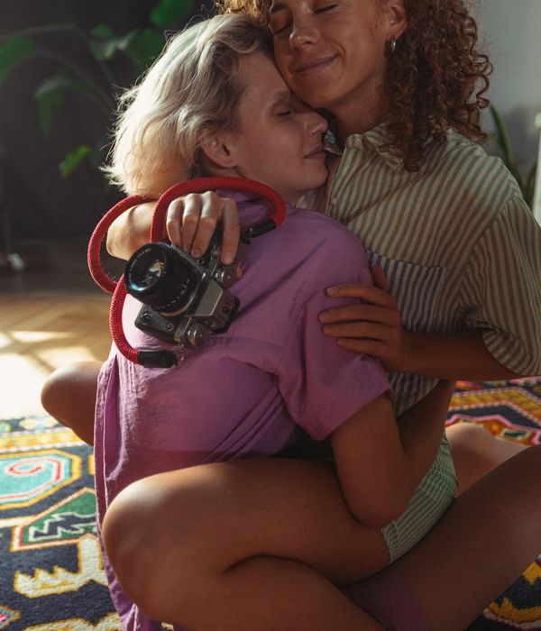 Woman photographer holding camera with warm smile